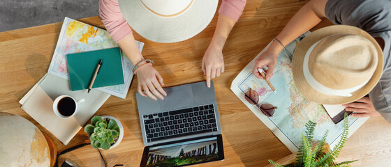 Top view of young couple with laptop planning vacation trip holiday, desktop travel concept.