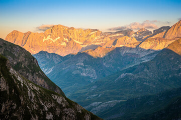 Beautiful sunset over the mountains, with the sun illuminating the high peaks and the valley remaining in shadow