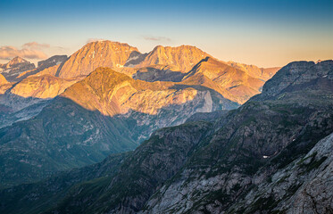 Beautiful sunset over the mountains, with the sun illuminating the high peaks and the valley remaining in shadow