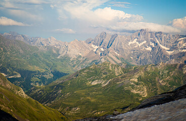 Beautiful view of snow-capped mountains and clouds over beautiful green valleys