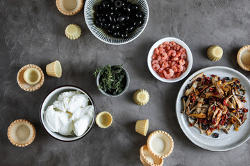 Ingredients for canapes on a dark background. Cooking snacks. Shrimp, mushrooms and cream cheese.