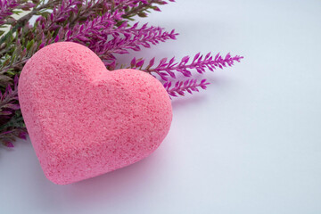 Obraz premium Purple heart bath salt and a branch of artificial lavender on a white background. Space for text