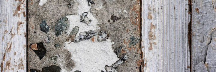Fragment of an old wall made of concrete and wood. Wide panoramic rustic texture for background and design.
