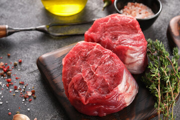 Raw beef filet Mignon steak on a wooden Board with pepper and salt, black Angus marbled meat.