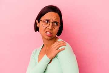 Young mixed race woman isolated on pink background having a shoulder pain.