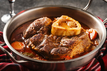 Italian menu: braised veal steak Ossobuco alla Milanese with  vegetable sauce close-up. Beef Leg...