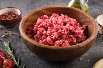 Fresh Raw mince, Minced beef, ground meat with herbs and spices in wooden plate.