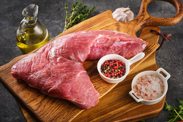 Raw beef tri-tip steak for BBQ on wooden board with salt, garlic and pepper, top view. - 417469778