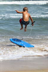 Adventurous agile Young boy catching air before catching a wave with his wakeboard in the Atlantic...