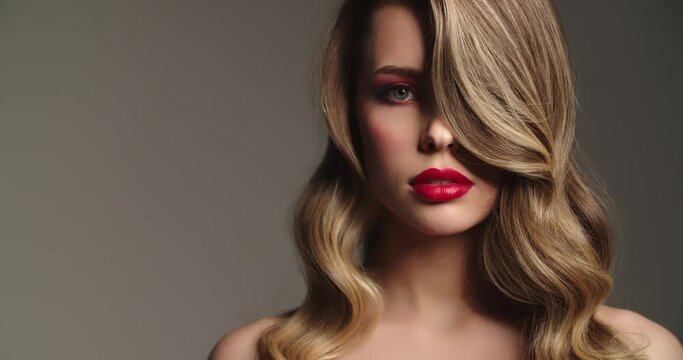 Pretty face of a white girl. Sexy model with a red lips. Fashion model raising head and looks to the camera.