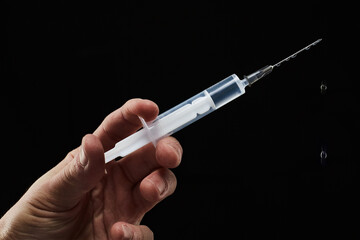 Hand hold medical syringe on Black background