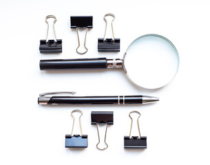 White office desk with magnifying glass, pen and clip for paper with copy space. Accounting work space