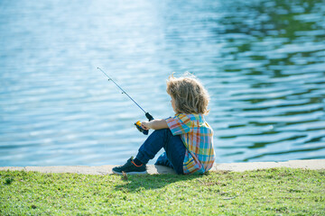 Fishing hobby. Child fishing on the lake. Boy with spinner at river. Kid at jetty with rod.