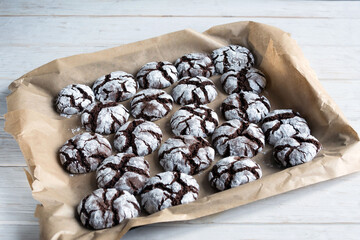 Delicious sweet brownie chocolate chip cookies sprinkled with powdered sugar on craft paper. Homemade baking.