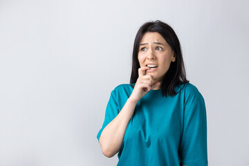 Portrait of a beautiful girl  in a blue t-shirt, looks aside with pensive expression, is considering a plan for further action.