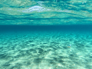 Fototapeta na wymiar Underwater sandy sea bed in tropical exotic turquoise bay