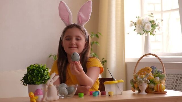 funny happy child girl playing with easter eggs at home