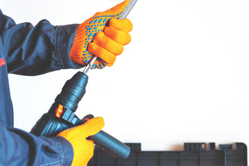 hands in protective gloves, hammer drill, chisel, bit,
