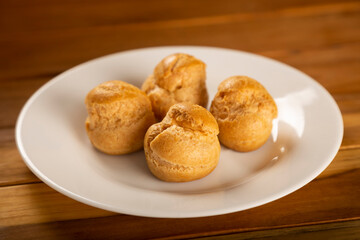 Obraz na płótnie Canvas Delicious profiteroles on the table. Profiteroles dessert. Image with selective focus.