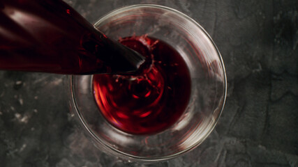 Red wine pouring into a glass, closeup