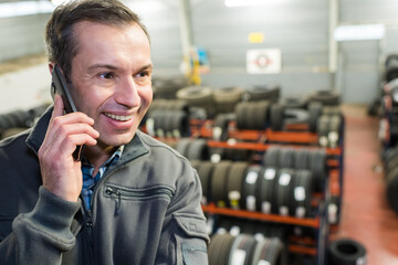 tire shop worker using his phone