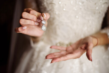 The bride holds an earring in her hand