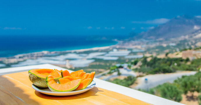 melon on a table with view on sea and mountain