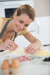 Obraz na płótnie Canvas happy woman in kitchen preparing pastries