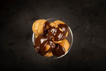 Profiteroles covered with chocolate sauce.