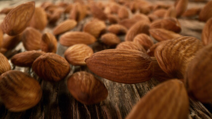 Rolling whole almonds nuts placed on wooden planks