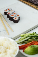 Sushi rolls prepared by professional asian chef with traditional Japanese ingredients. Salmon, rice, vegetables, sesame seeds. 