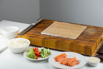 Sushi rolls prepared by professional asian chef with traditional Japanese ingredients. Salmon, rice, vegetables, sesame seeds. 