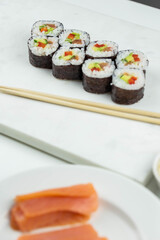 Sushi rolls prepared by professional asian chef with traditional Japanese ingredients. Salmon, rice, vegetables, sesame seeds. 