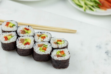 Sushi rolls prepared by professional asian chef with traditional Japanese ingredients. Salmon, rice, vegetables, sesame seeds. 