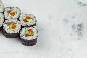 Sushi rolls prepared by professional asian chef with traditional Japanese ingredients. Salmon, rice, vegetables, sesame seeds. 