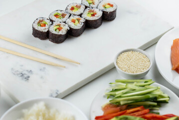 Sushi rolls prepared by professional asian chef with traditional Japanese ingredients. Salmon, rice, vegetables, sesame seeds.  Sushi cooking and making concept