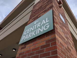a large 'Central Parking' sign on a brick wall outside a parking garage