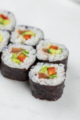 Sushi rolls prepared by professional asian chef with traditional Japanese ingredients. Salmon, rice, vegetables, sesame seeds. 