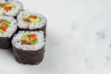 Sushi rolls prepared by professional asian chef with traditional Japanese ingredients. Salmon, rice, vegetables, sesame seeds. 