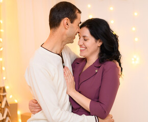 portrait of adult couple in home interior decorated with lights