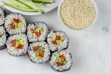 Sushi rolls prepared by professional asian chef with traditional Japanese ingredients. Salmon, rice, vegetables, sesame seeds. 