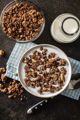 Chocolate breakfast cereal. Morning granola with milk in bowl.