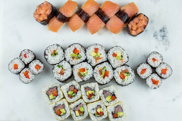 Sushi rolls prepared by professional asian chef with traditional Japanese ingredients. Salmon, rice, vegetables, sesame seeds. 