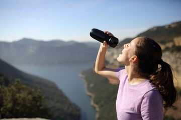 Runner drinking water from bottle in the mountain