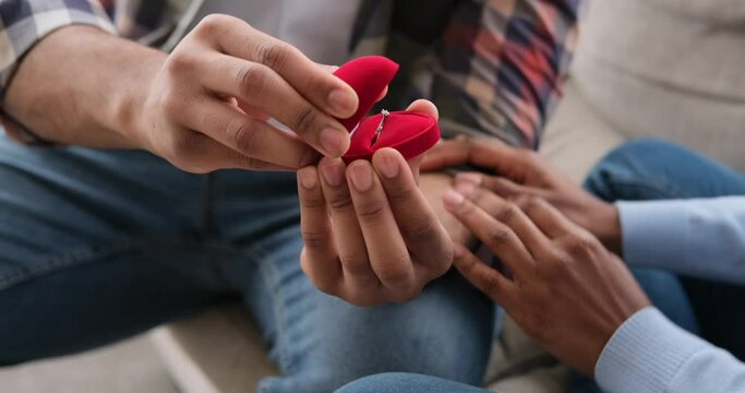 Man putting ring on finger of his fiancee after marriage proposal