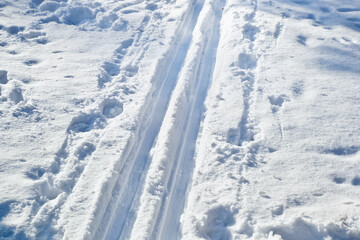 Fototapeta na wymiar Ski track left by skiers on a city square in winter day