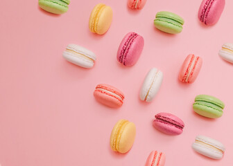 Macaroons Top view photo with copy space  White, yellow, pink, orange, and green almond cookies on light pink background