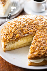 Sliced sweet almond cake. Pie with cream and almonds.