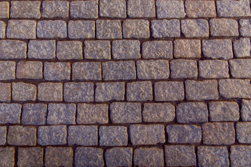 pattern brown color of old granite stone wall uneven cracked real stone wall surface with cement