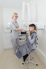 Obraz premium Dentist make jaw x-ray image for little boy in dental clinic